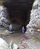 Two students posing near the entrance to a cave