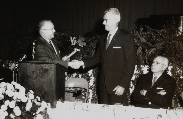 Dr. Isaac Beckes presenting an award on stage