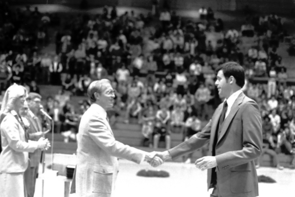 Isaac K. Beckes shaking hands in the Vincennes University basketball arena