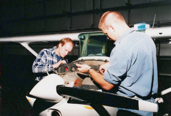 Aviation students working on aircraft engine