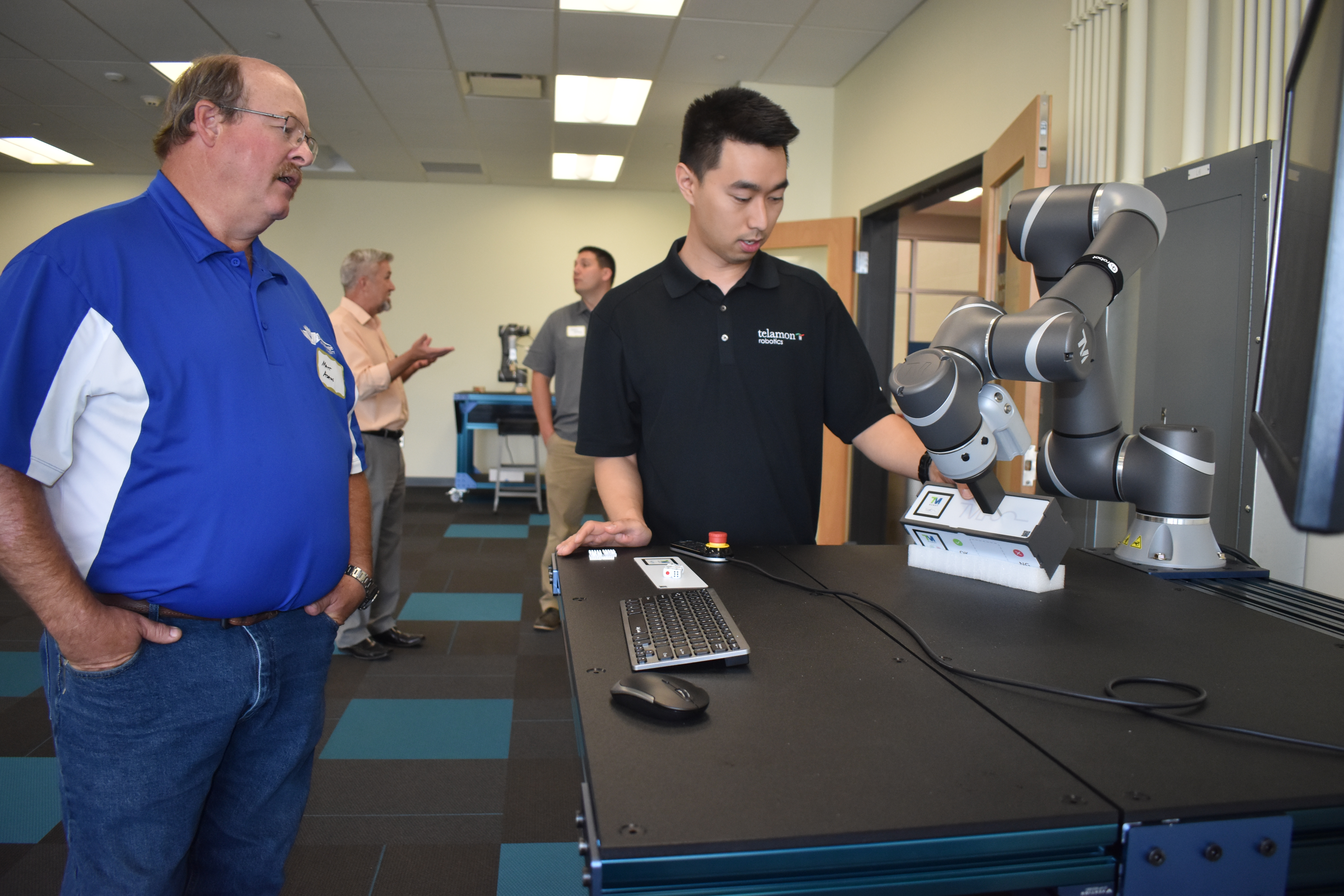 A Telamon Robotics employee demonstrates use of cobot to an instructor