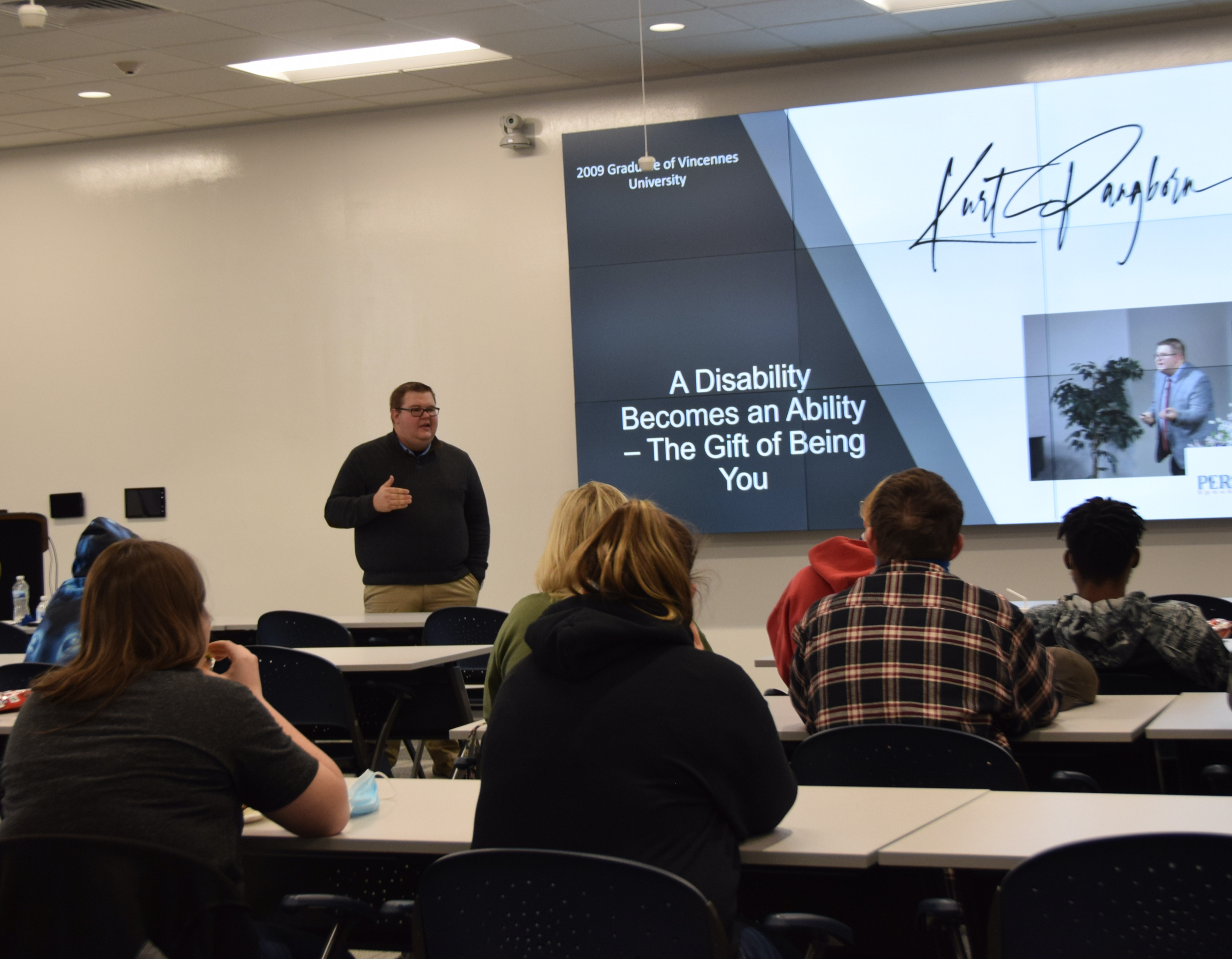 VU graduate Kurt Pangborn shares his life story with while standing in front of students in the Innovation Room at the Shake Learning Resource Center. 