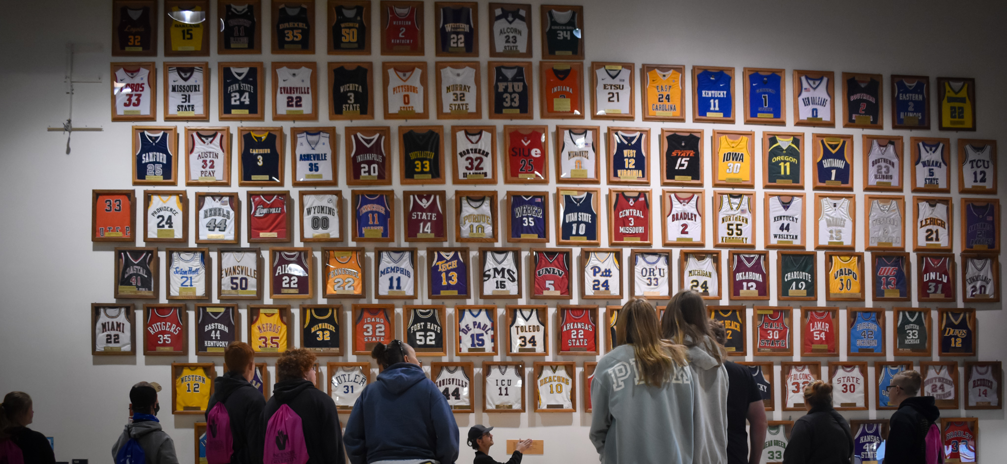 Prospective students and families check out a wall of basketball jerseys during a tour of the PE Complex
