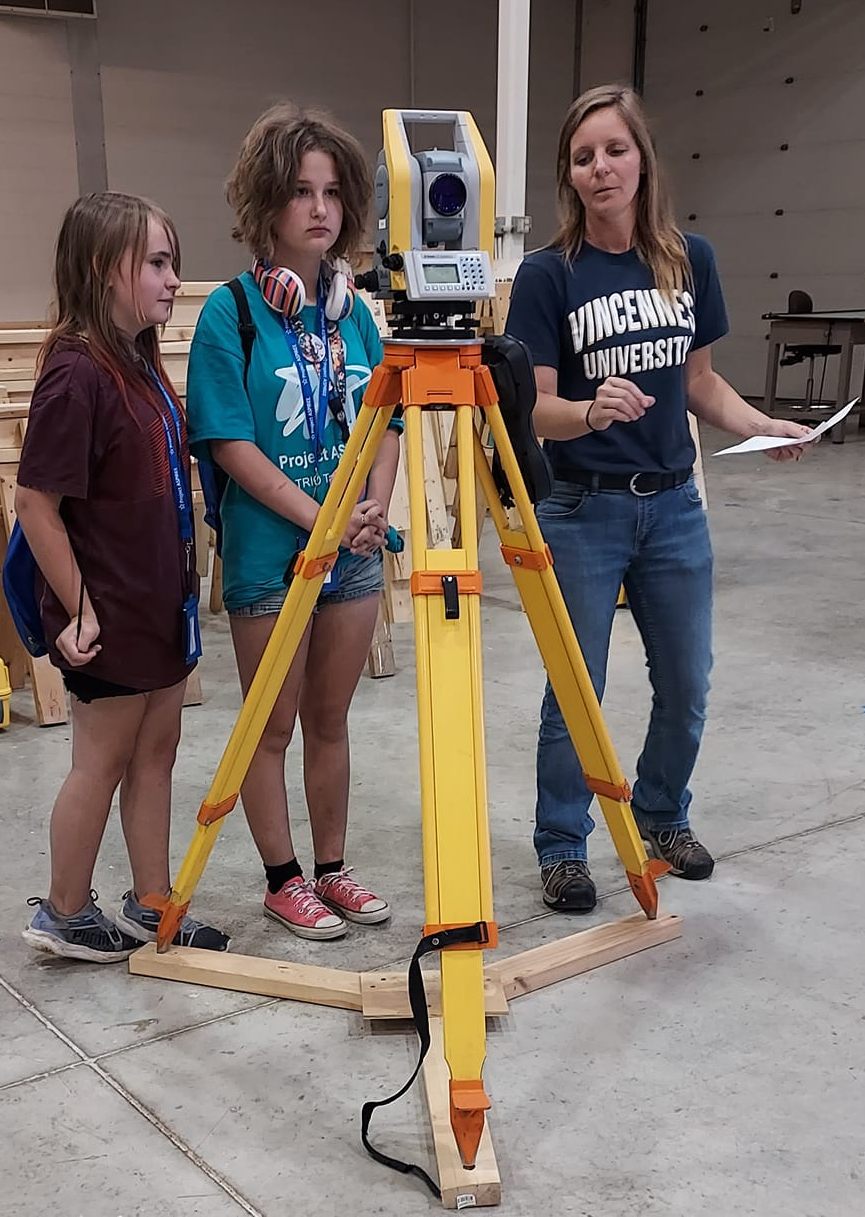 VU Professor Jessica Hess teaching two Project ASPIREE students about Surveying equipment.
