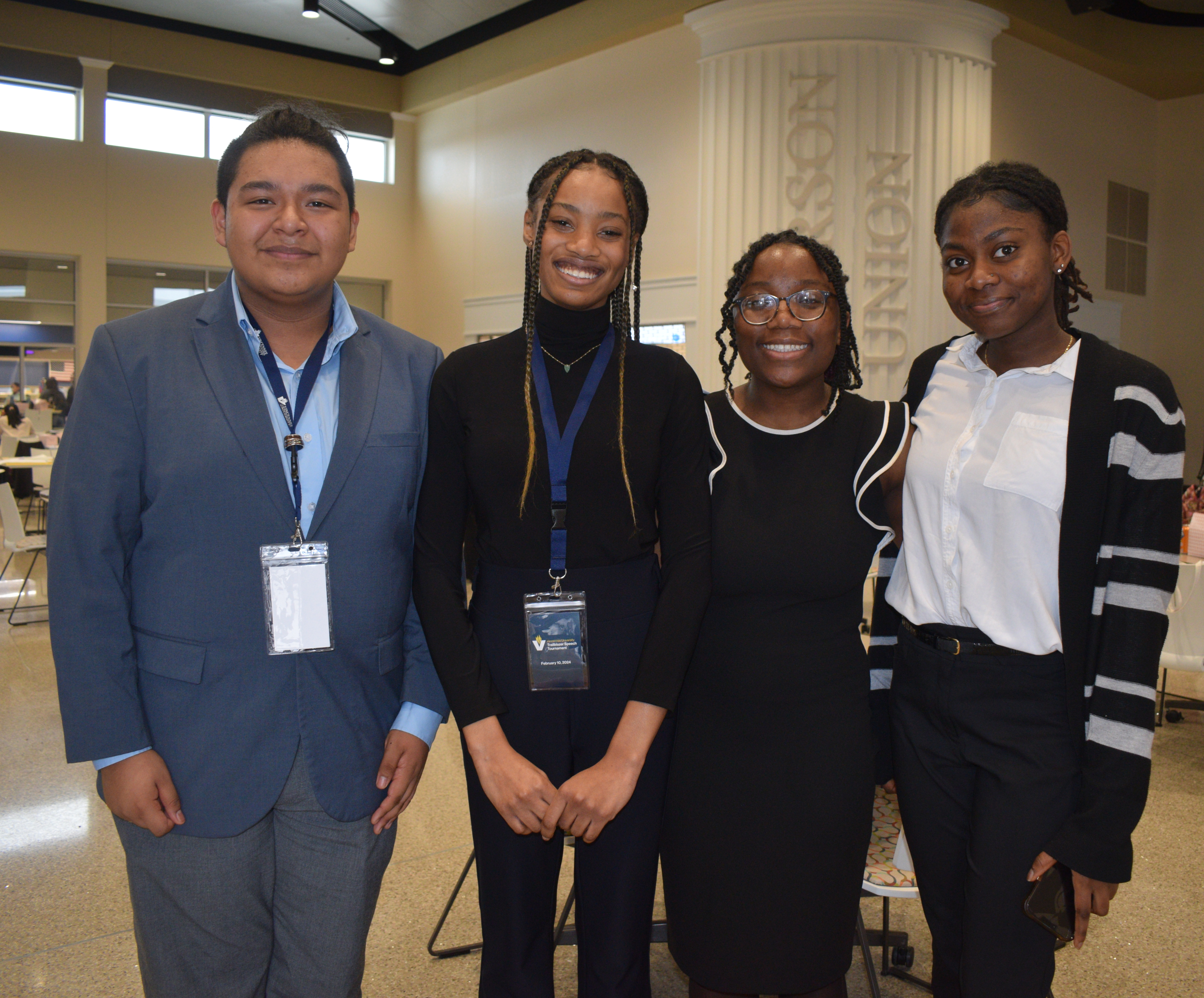 Four high school students of color dressed in professional attire pose for a photograph in Jefferson Student Union.