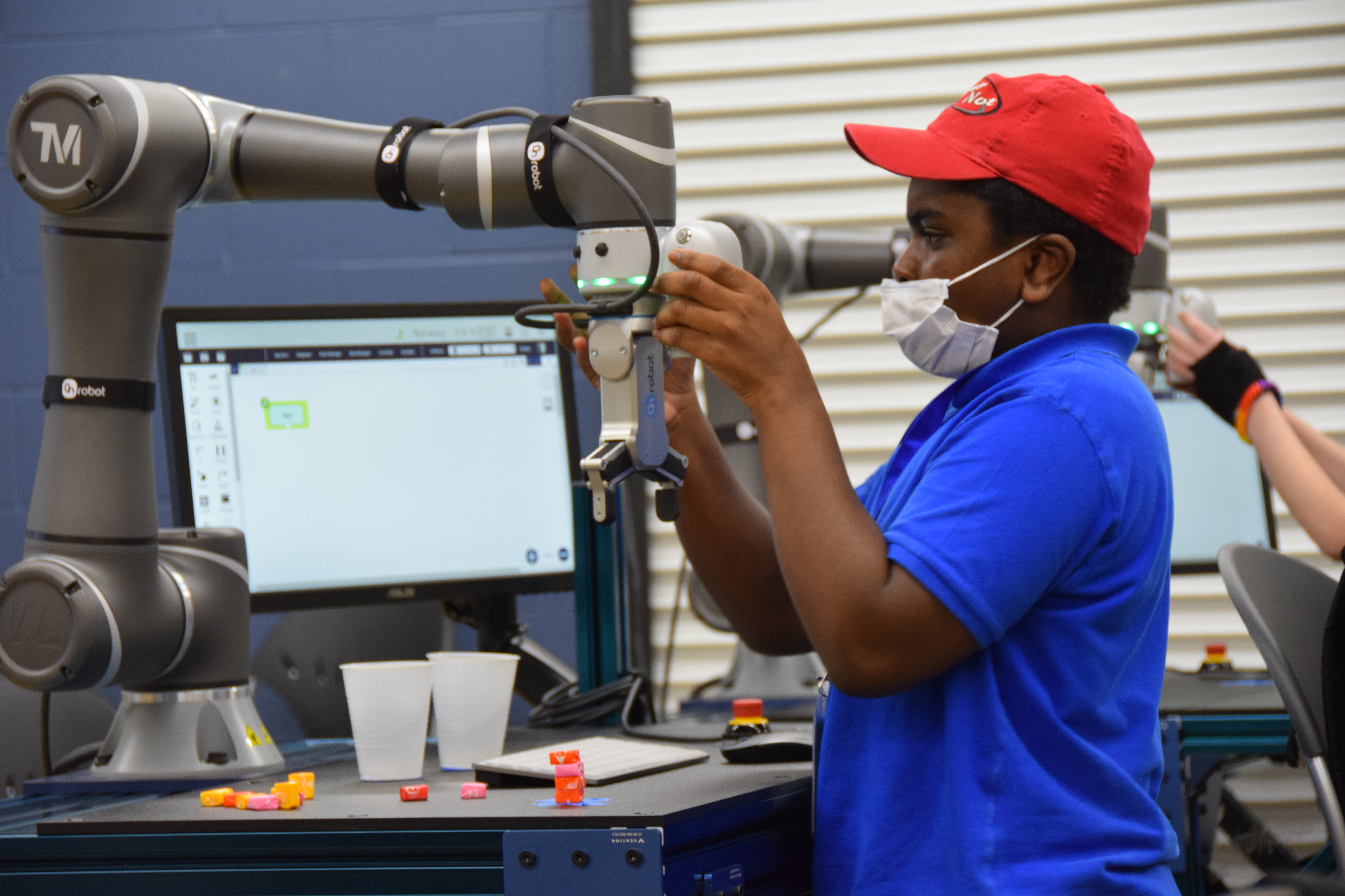 A high school student attending the VU Jasper STEM Academy programs a collaborative robot or cobot in the Cobot Learning Lab in the CTIM on the VU Jasper Campus.